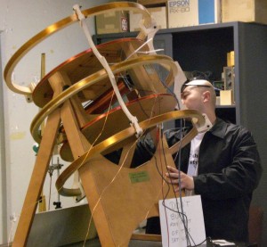 Male standing over a coil arrangement apparatus.