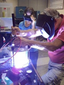 Female and Male sitting making samples of uranium crystals.