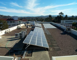 Six solar panels on the physics building roof on a sunny day.