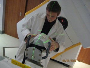 Male standing over medical imaging device.