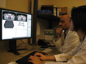 Male and female sitting looking at computer monitor.
